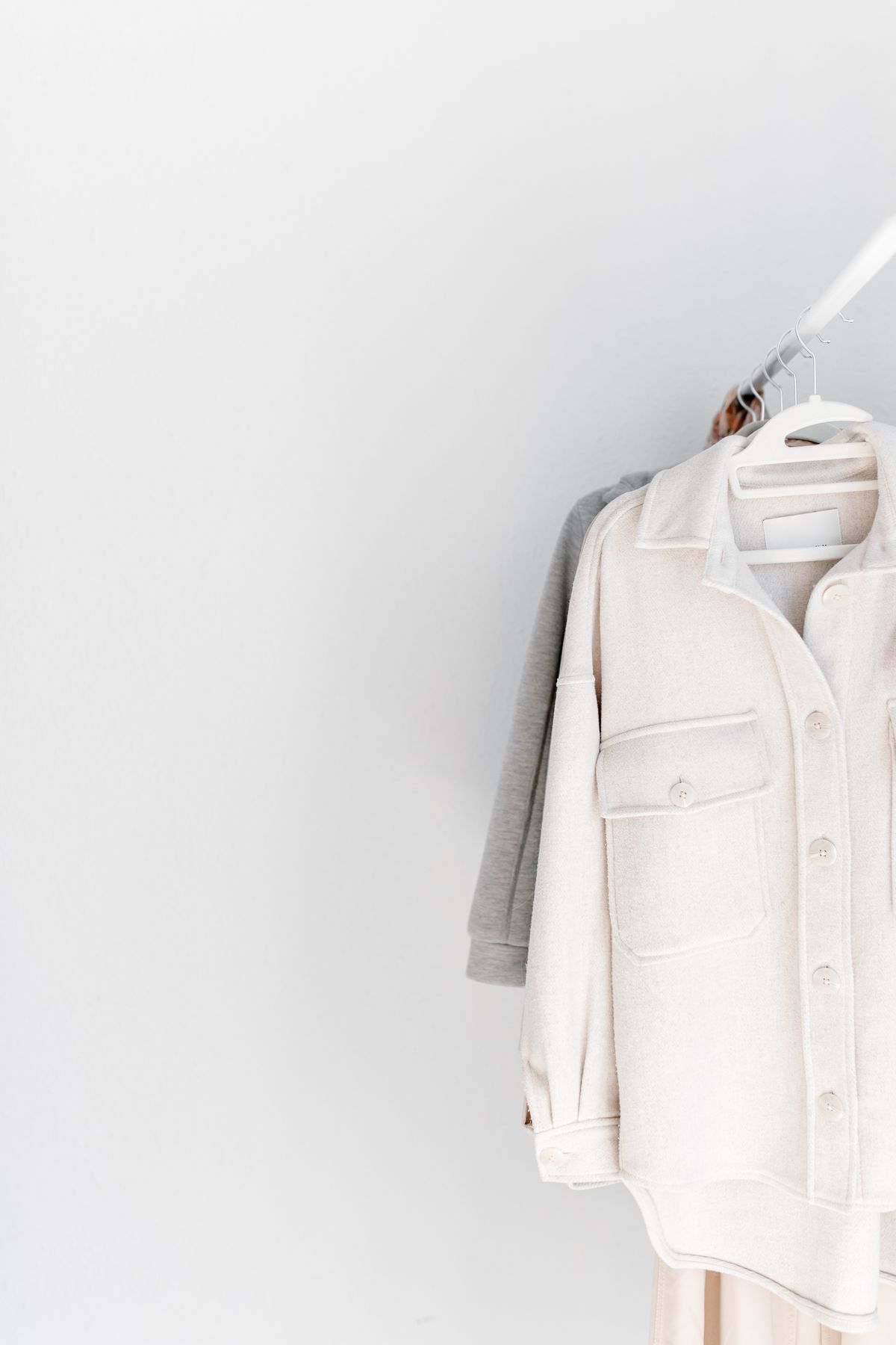 A cream jacket on a clothes rail